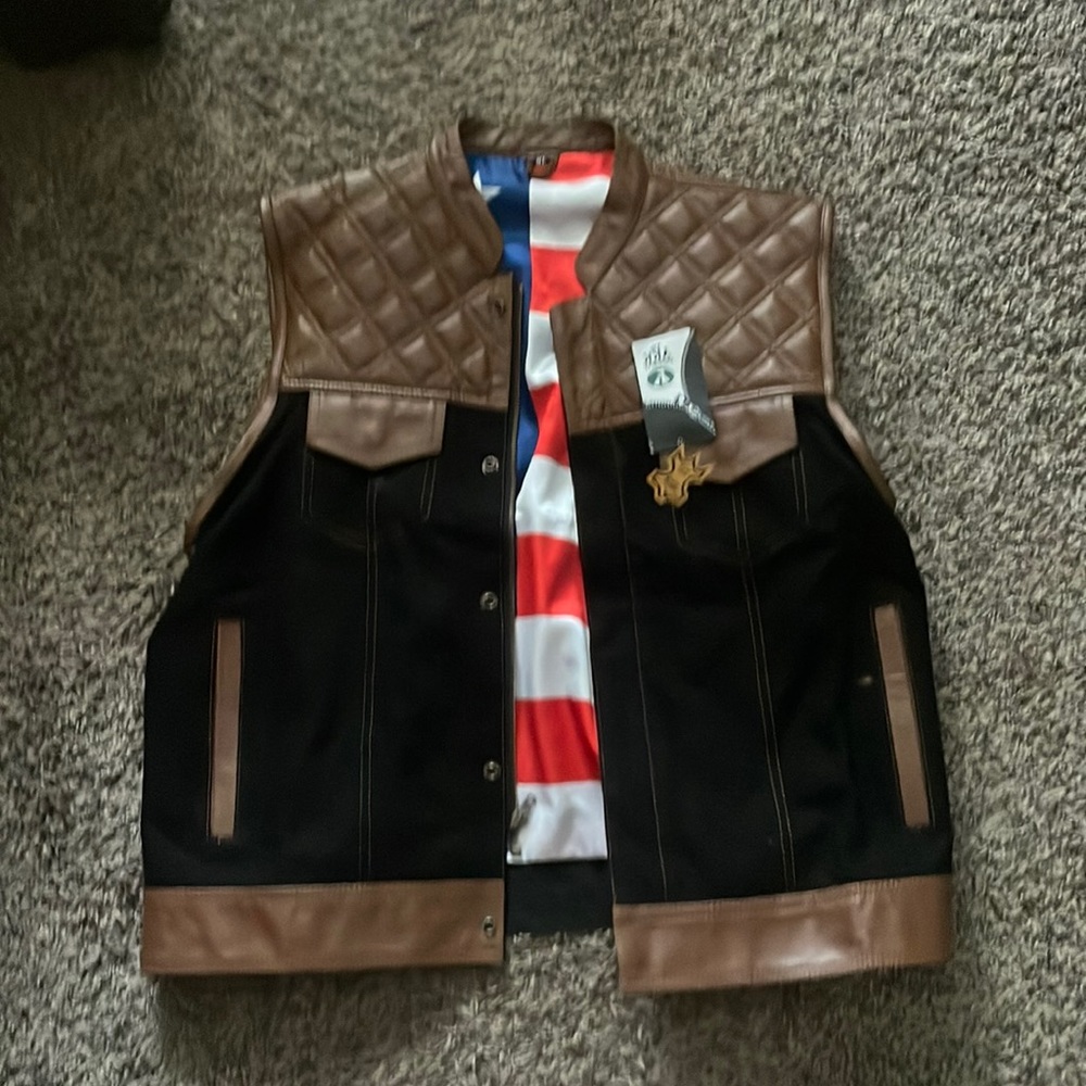 Motorcycle vest. Black denim and brown leather. No brand on it.